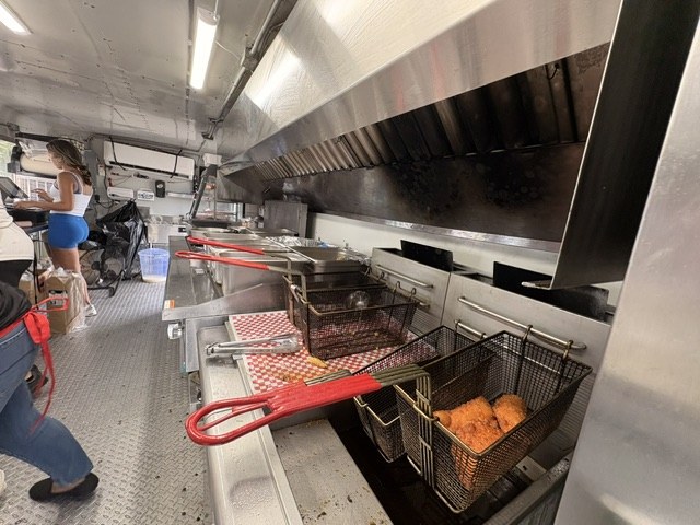 Fryer baskets holding golden fried food inside the food truck