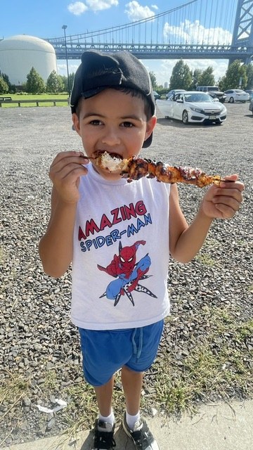 A young guest enjoying a pincho with the bridge in the background