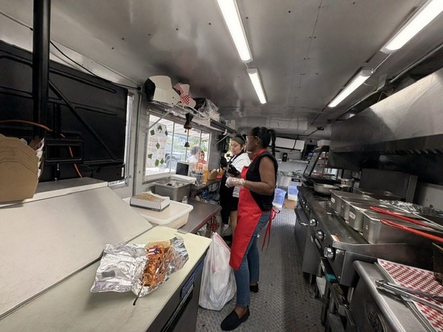 Kitchen crew preparing orders inside the CoquiEats truck