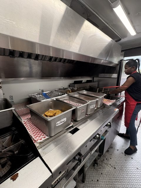CoquiEats team member preparing food in the truck kitchen