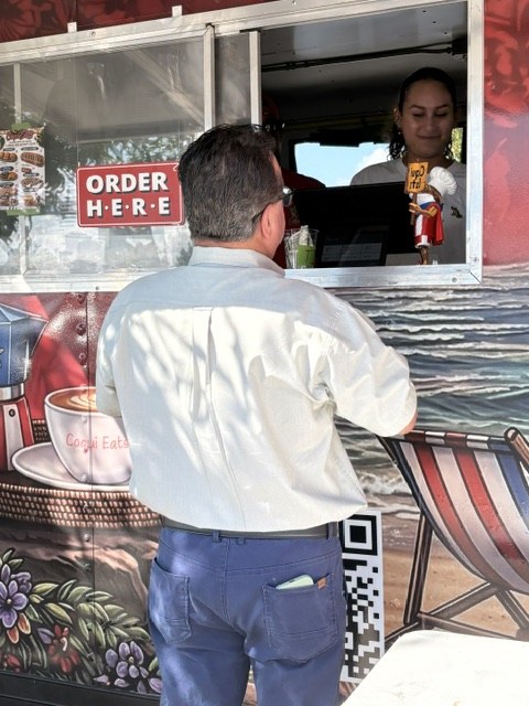 A guest ordering at the CoquiEats truck window