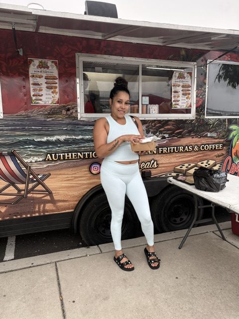 A customer enjoying her CoquiEats order in front of the truck