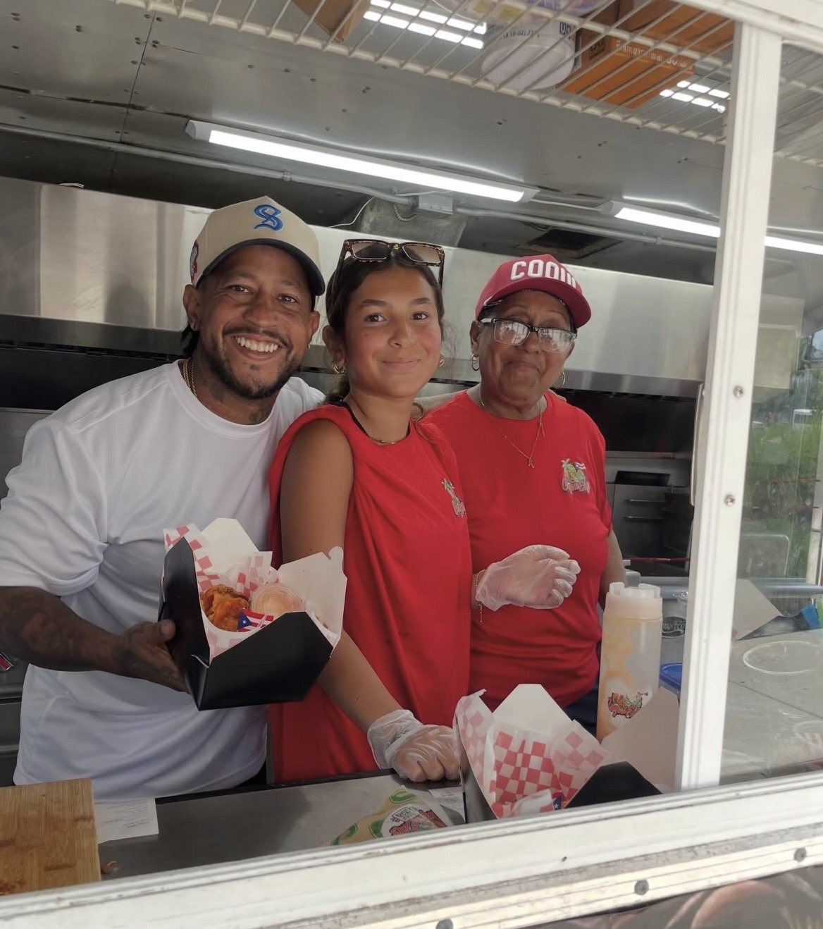 The CoquiEats team serving customers from inside the food truck window